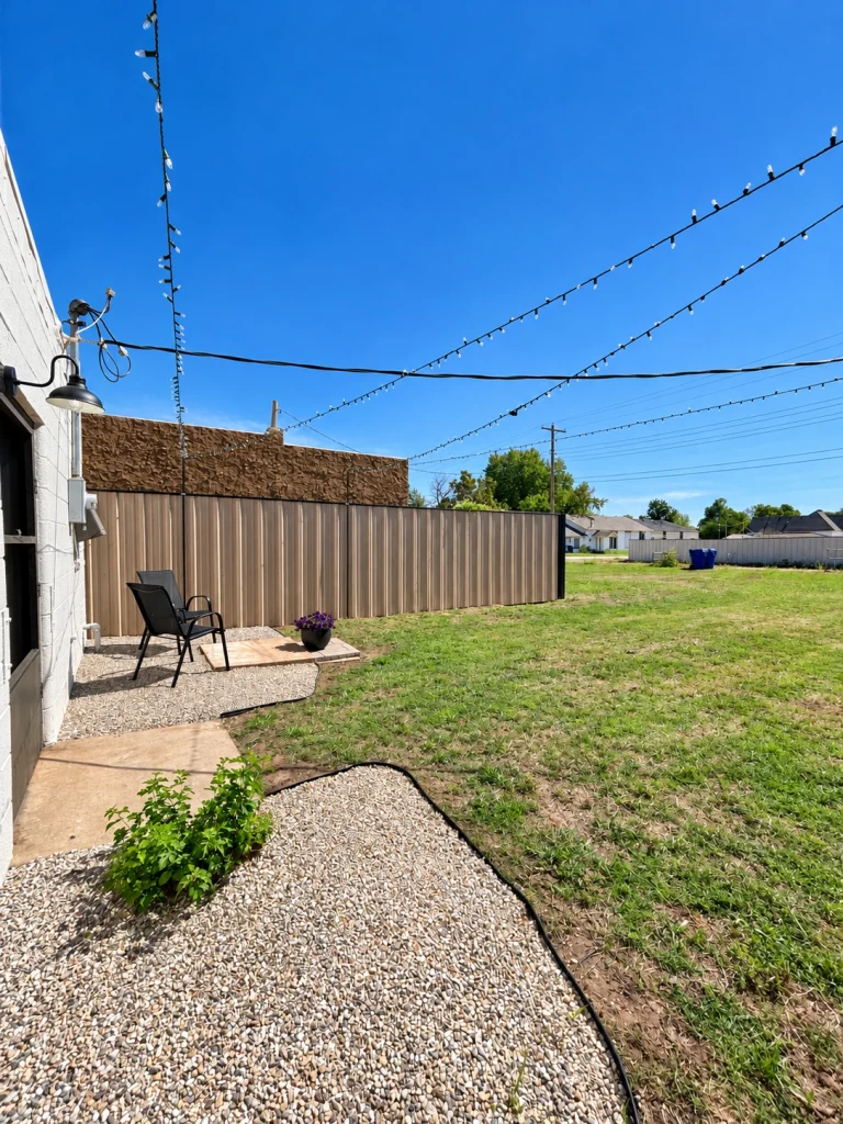 Home Rear yard with gravel landscaping, small garden bed, and grassy outdoor area.