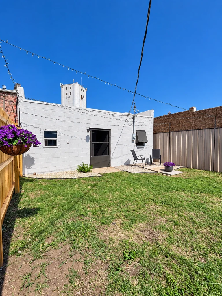 Home Back of the commercial building showing rear door, windows, and grassy yard.