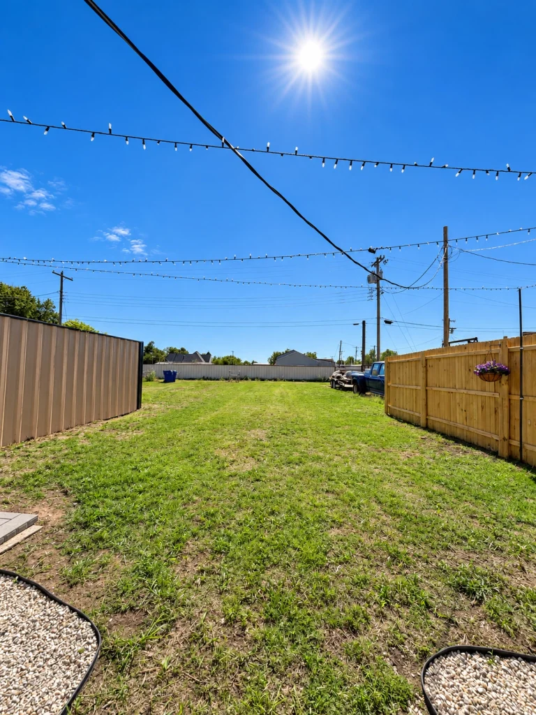 Home Rear yard looking toward the alley with fencing on both sides.
