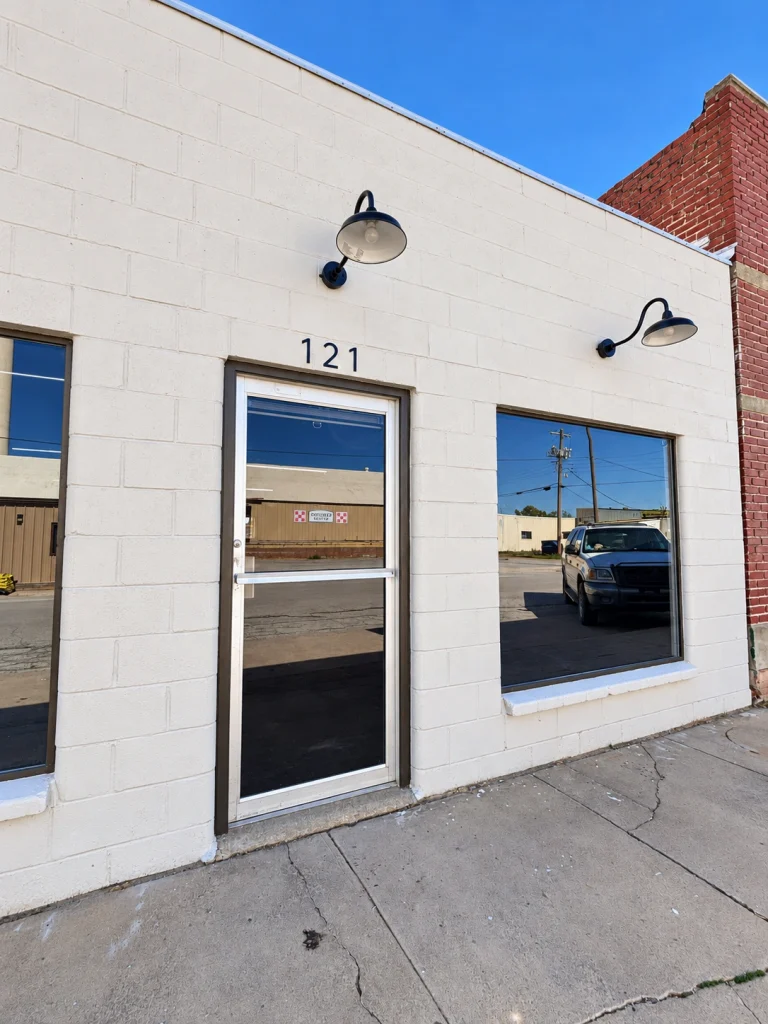 Home Angled close-up of the commercial storefront's glass entry door and front windows.